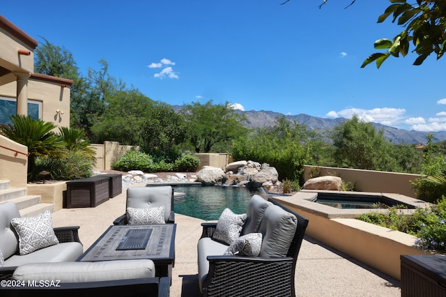 view of patio featuring a swimming pool with hot tub, a mountain view, and outdoor lounge area