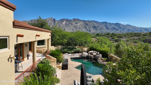 view of swimming pool featuring a mountain view and a patio area