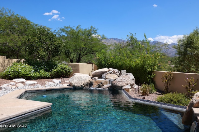 view of pool with a mountain view and pool water feature