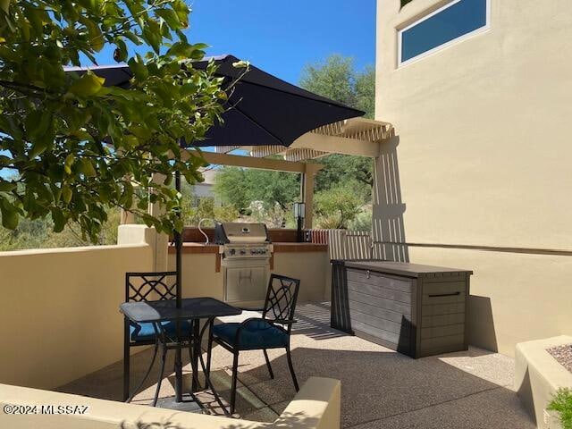 view of patio / terrace with area for grilling, a pergola, and exterior kitchen