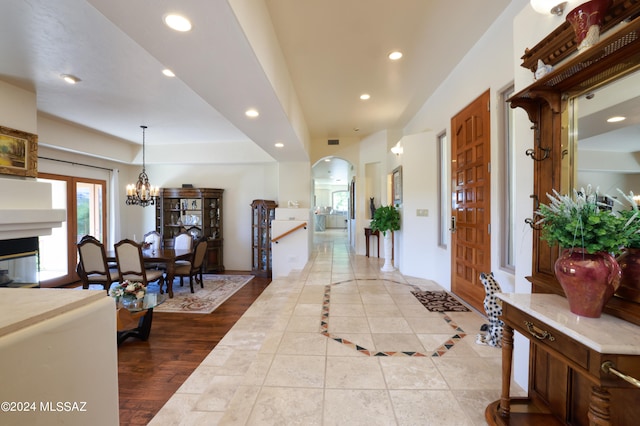 hall featuring light tile patterned floors and a chandelier