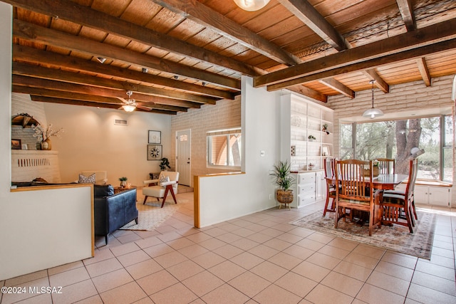 living room featuring beamed ceiling, light tile patterned flooring, a fireplace, and wooden ceiling