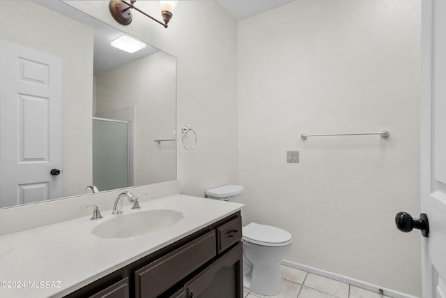 bathroom featuring vanity, toilet, a shower with shower door, and tile patterned flooring