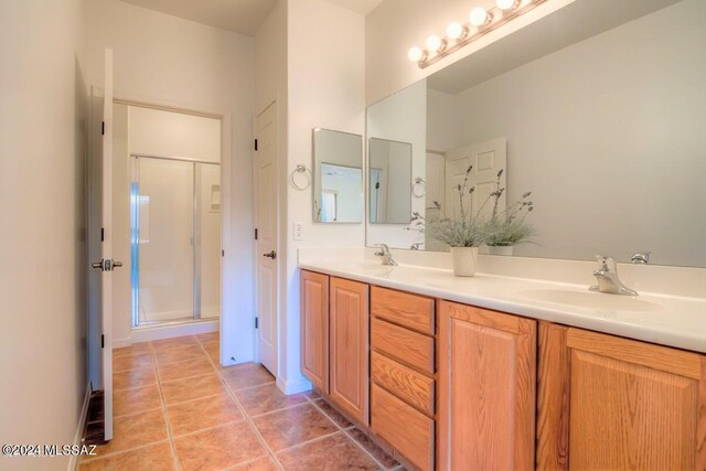 bathroom featuring tile patterned flooring, vanity, and a shower with shower door