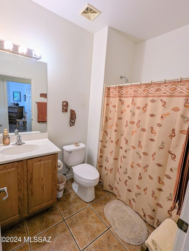 bathroom with tile patterned flooring, vanity, toilet, and curtained shower