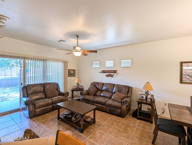 living room featuring tile patterned flooring, ceiling fan, and a healthy amount of sunlight