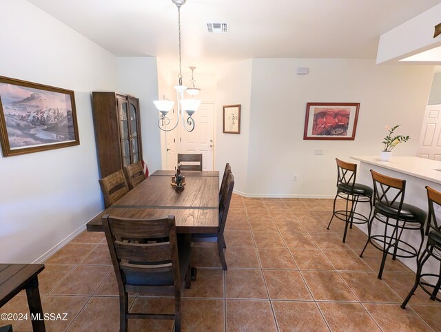 dining room with a notable chandelier and tile patterned flooring