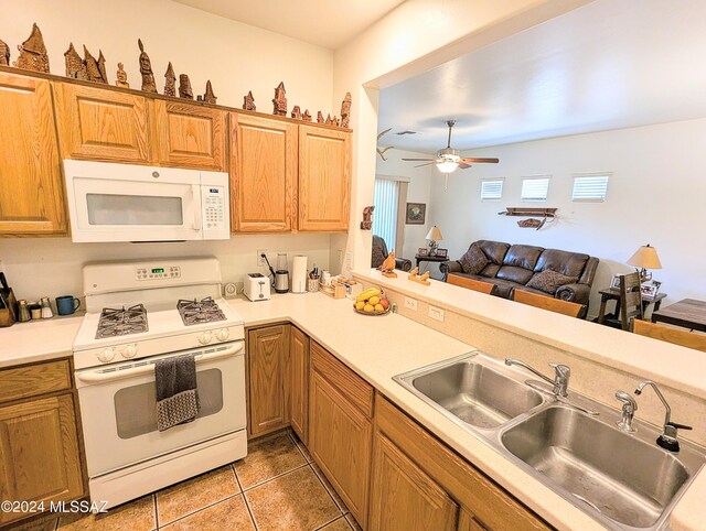 kitchen featuring tile patterned floors, white appliances, ceiling fan, and sink