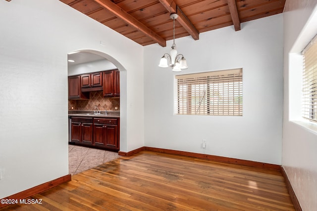 unfurnished dining area featuring wooden ceiling, light hardwood / wood-style floors, sink, an inviting chandelier, and vaulted ceiling with beams