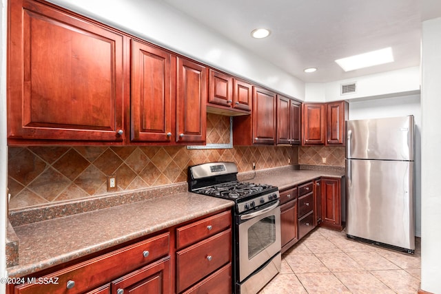 kitchen featuring tasteful backsplash, appliances with stainless steel finishes, and light tile patterned floors