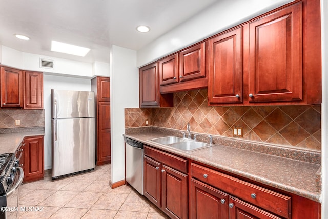 kitchen with stainless steel appliances, light tile patterned flooring, sink, and tasteful backsplash