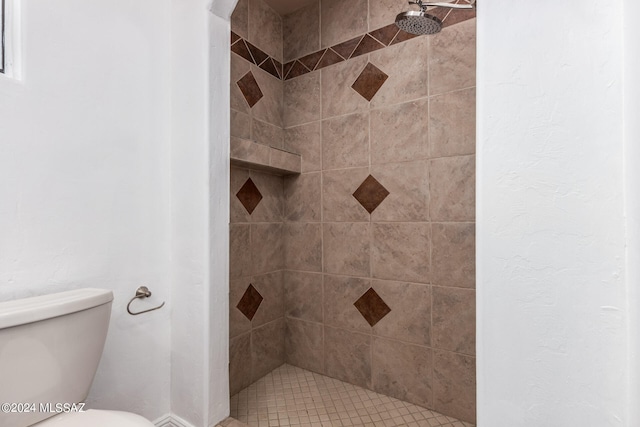 bathroom featuring a tile shower and toilet