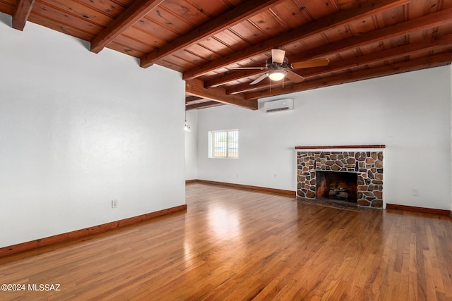 unfurnished living room with hardwood / wood-style floors, a wall unit AC, a fireplace, and wooden ceiling