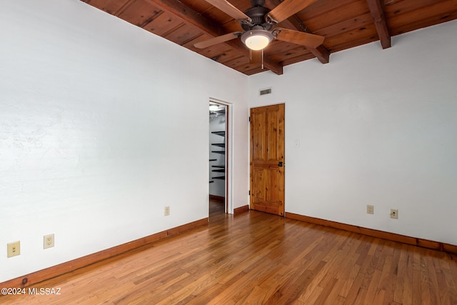 unfurnished bedroom featuring a spacious closet, wood-type flooring, ceiling fan, and wooden ceiling