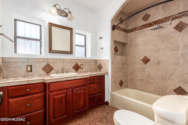 full bathroom with toilet, vanity, a healthy amount of sunlight, and tile patterned floors