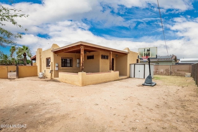 back of property with a storage shed