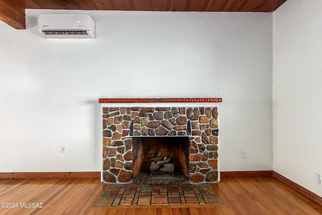 interior details featuring wood-type flooring, a wall mounted AC, a stone fireplace, beam ceiling, and wood ceiling