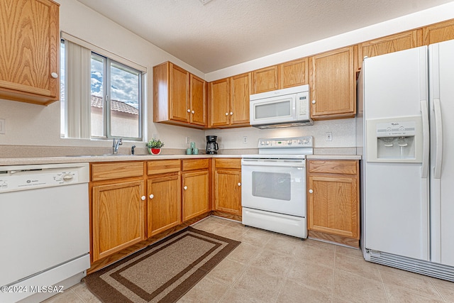 kitchen featuring white appliances and light tile patterned flooring