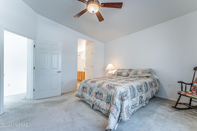 carpeted bedroom featuring vaulted ceiling, ensuite bath, and ceiling fan