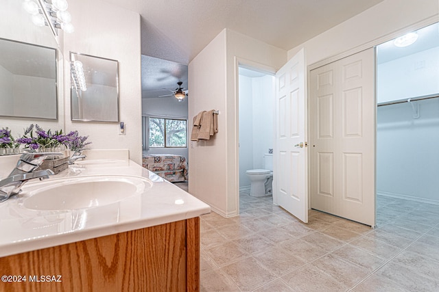 bathroom with tile patterned flooring, ceiling fan, toilet, and vanity