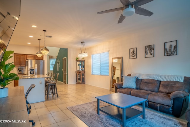 living room featuring plenty of natural light, ceiling fan with notable chandelier, and light tile patterned flooring