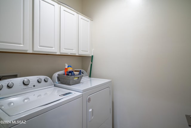 washroom featuring cabinets and washer and dryer