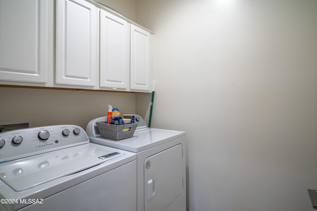 clothes washing area with cabinet space and washing machine and dryer