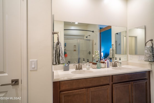 bathroom featuring vanity and a shower with door