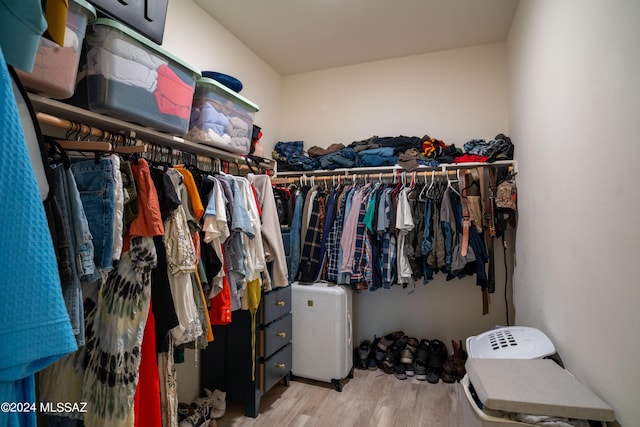 walk in closet with wood finished floors