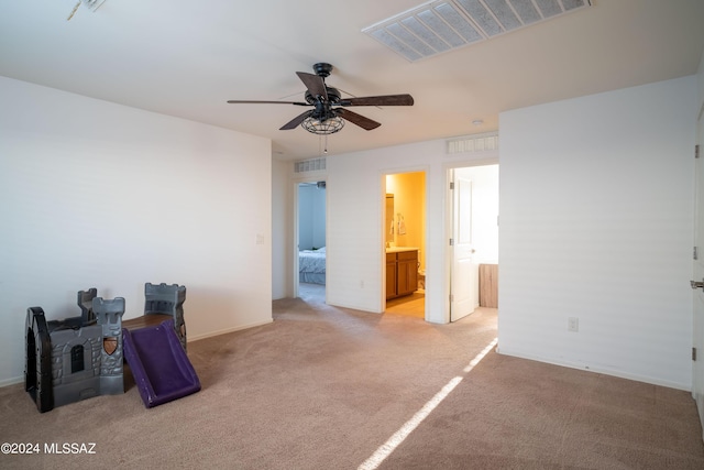 interior space with visible vents, light colored carpet, and ensuite bath