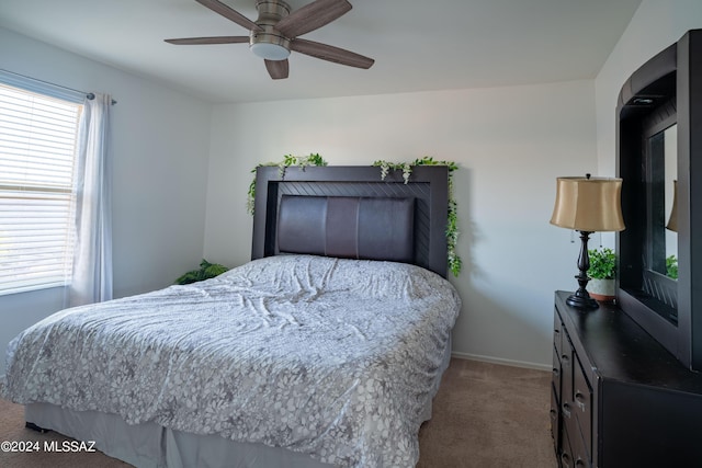 carpeted bedroom with a ceiling fan and baseboards