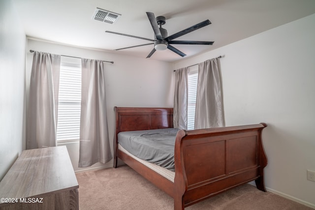 carpeted bedroom with ceiling fan and multiple windows