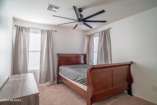 bedroom with visible vents, baseboards, light colored carpet, and a ceiling fan