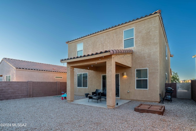 back of house with a tiled roof, a fenced backyard, stucco siding, and a patio area