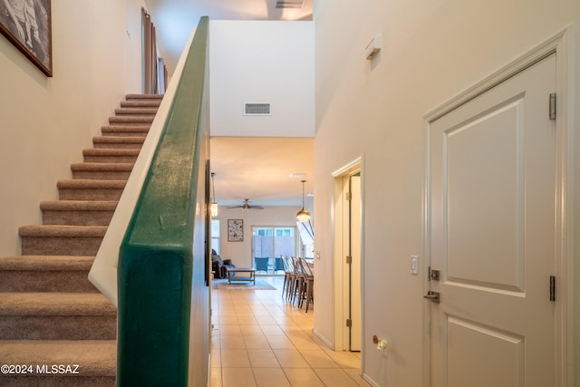 staircase with tile patterned flooring, visible vents, and ceiling fan