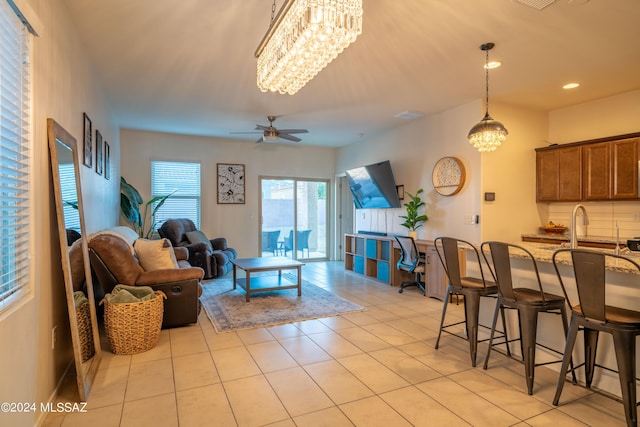 living area featuring visible vents, light tile patterned flooring, ceiling fan with notable chandelier, and recessed lighting