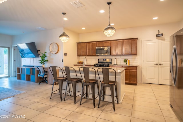 kitchen featuring visible vents, light tile patterned floors, decorative backsplash, brown cabinets, and appliances with stainless steel finishes