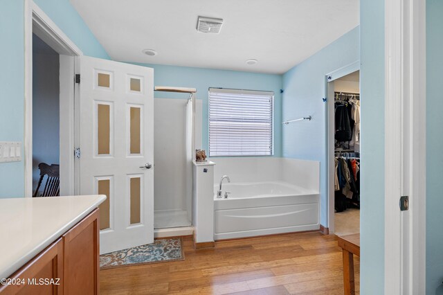 bathroom featuring vanity, hardwood / wood-style flooring, and independent shower and bath