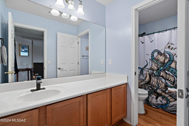 bathroom featuring a shower with curtain, toilet, hardwood / wood-style flooring, and vanity