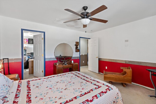 bedroom with ceiling fan, light carpet, and connected bathroom