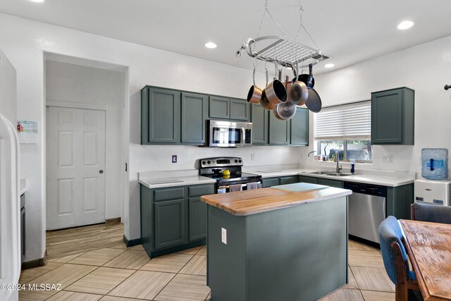 kitchen featuring appliances with stainless steel finishes, a center island, and sink