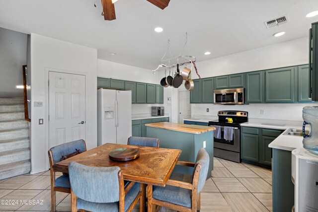 kitchen with ceiling fan with notable chandelier, green cabinets, and appliances with stainless steel finishes