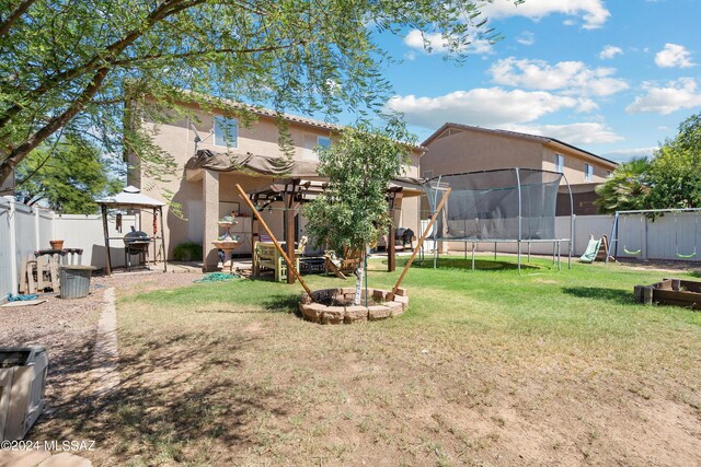 view of yard with an outdoor fire pit, a gazebo, a patio area, and a trampoline