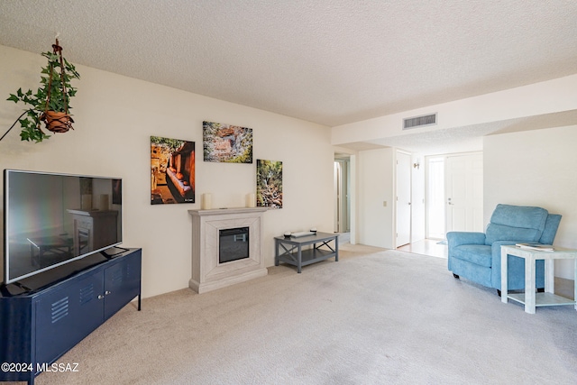 living area featuring a textured ceiling, carpet, and a fireplace