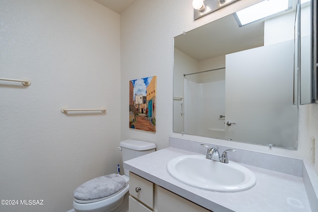 bathroom featuring vanity, toilet, and walk in shower