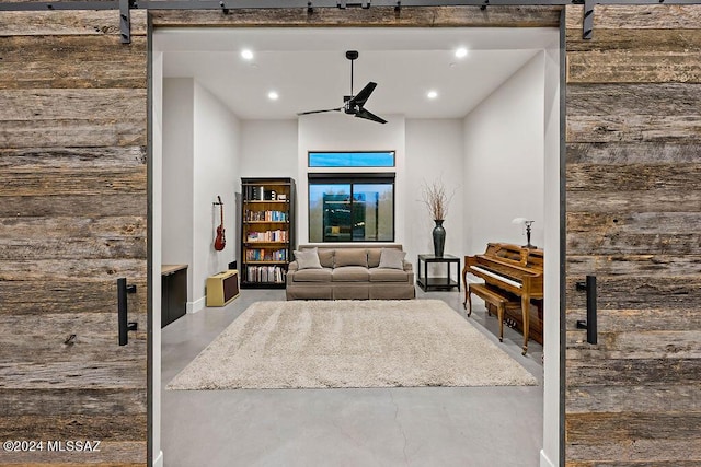 living area featuring recessed lighting, a barn door, concrete flooring, and a ceiling fan