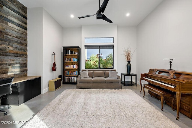 living area with a ceiling fan, recessed lighting, baseboards, and concrete flooring