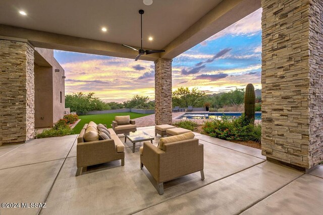 patio terrace at dusk featuring an outdoor living space and ceiling fan