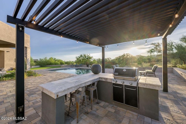 view of patio featuring grilling area, outdoor wet bar, an outdoor kitchen, an outdoor pool, and a pergola