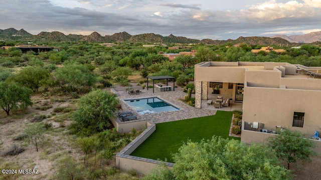 exterior space featuring a mountain view, an outdoor living space, a yard, and a patio